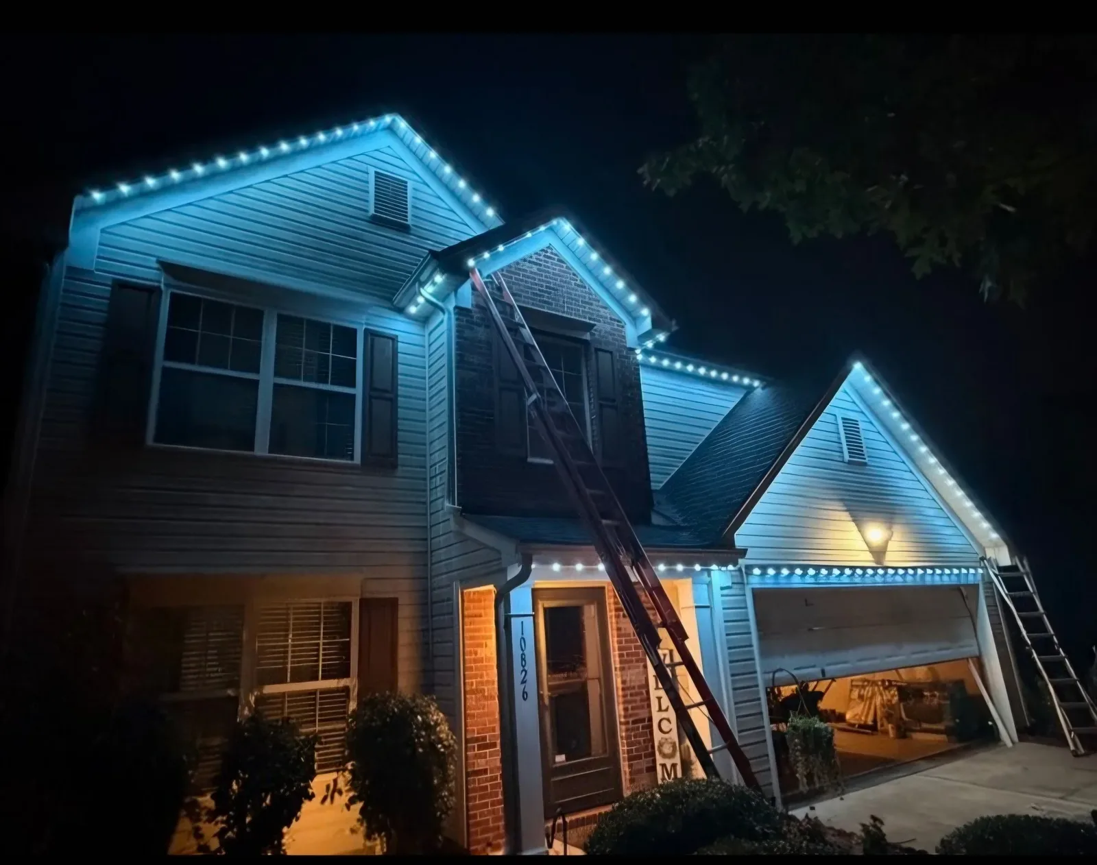 The Vision Home Innovations crew finishing a permanent lighting install at dusk